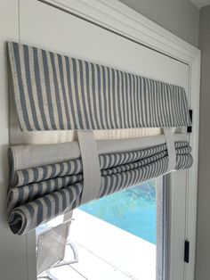 a close up of a window with blinds on the windowsill and a pool in the background