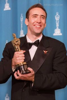 a man in a tuxedo holding an award