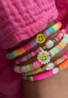 a person wearing bracelets with smiley faces on them