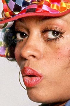 a close up of a person wearing a colorful hat with large, square shaped eyes