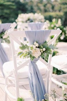 white chairs with blue sashes and flowers on them