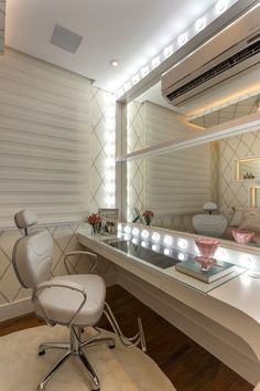 a white chair sitting in front of a mirror on top of a counter next to a sink