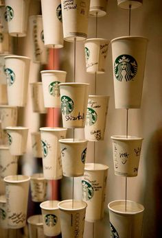 many starbucks cups are lined up on the wall