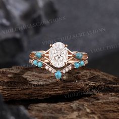 a diamond and turquoise stone ring sitting on top of a rock