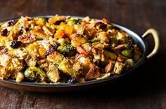 a pan filled with stuffing and vegetables on top of a table