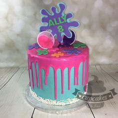 a birthday cake with pink and blue icing on it's top, decorated with the name ally 8