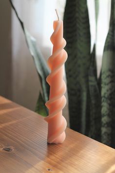 a tall candle sitting on top of a wooden table