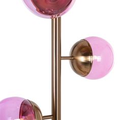 two pink glass balls on a brass metal pole with one light turned on and the other turned off