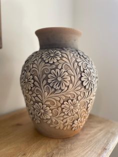 a vase sitting on top of a wooden table