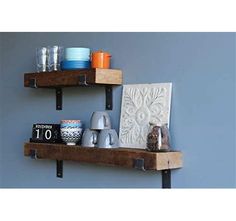 two wooden shelves with metal brackets holding cups and other items on top of each shelf