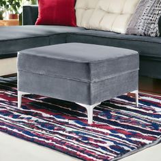 a gray ottoman sitting on top of a rug