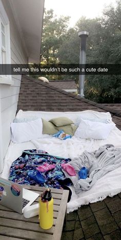 a bed sitting on top of a wooden floor next to a window and a laptop