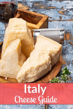 some cheese is on a wooden plate with a grater and glass of wine in the background