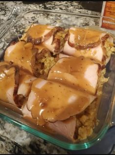 a glass casserole dish filled with chicken and rice covered in gravy