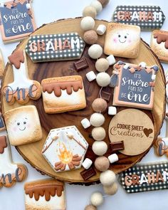 some cookies are on a wooden plate and decorated with different types of icing decorations