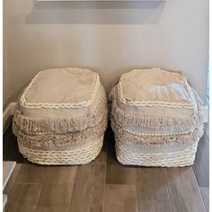 two white baskets sitting on top of a wooden floor