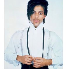 a man with black hair wearing suspenders and a white shirt