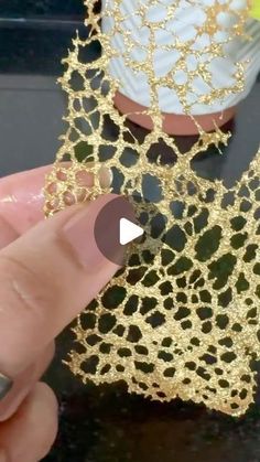 someone is holding onto some gold lace