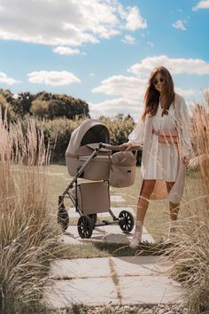 a woman standing next to a baby stroller