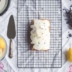 a piece of bread sitting on top of a cooling rack next to some lemons