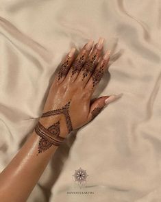 a woman's hand with henna tattoos on it