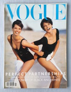 two women in swimsuits on the cover of a magazine, one is holding another woman's leg