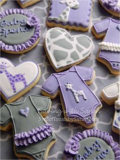 baby shower cookies decorated with purple and gray icing on a grey tablecloth background