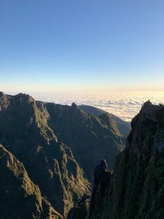 the mountains are covered in clouds and grass