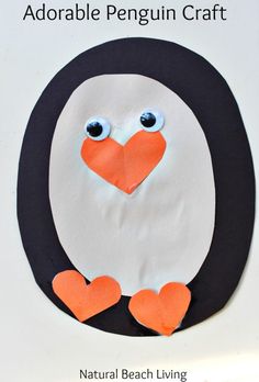 a penguin made out of paper with hearts on it's chest and eyes painted orange