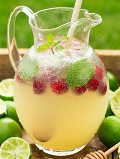 a pitcher filled with lemonade and raspberries