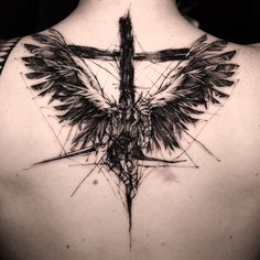 the back of a man's shoulder with a cross and wings on it