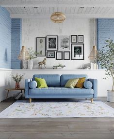 a living room with blue couches and pictures on the wall above them, along with potted plants