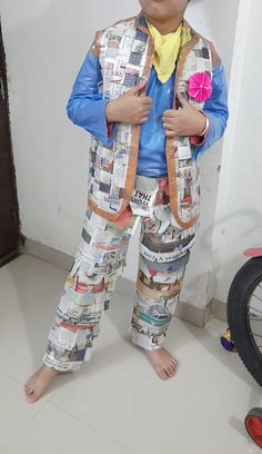 a young boy dressed up in newspaper paper