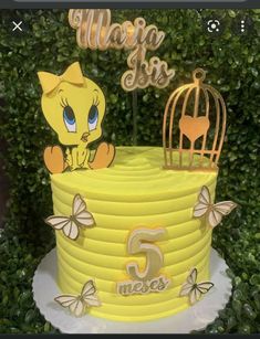 a yellow cake with a birdcage on top and the number five in front