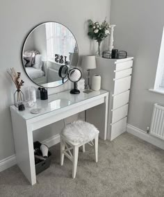 a white desk with a mirror and stool