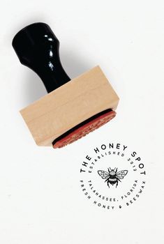 a rubber stamp with a bee on it and the words, the honey shop written in black ink