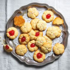 cookies with jelly and sprinkles are on a plate, ready to be eaten