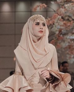 a woman in a hijab walks down the runway