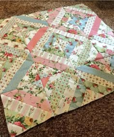 a patchwork quilt is laying on the floor