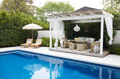 an outdoor living area next to a swimming pool