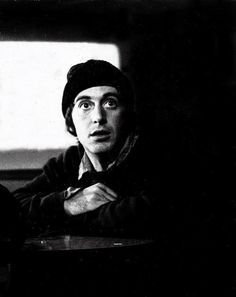 black and white photograph of two people sitting at a table with one person looking up