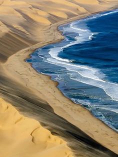 an aerial view of the ocean and sand dunes