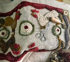 a pair of scissors sitting on top of a table next to some crochet