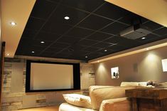 a home theater with two couches and a projector screen