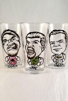 three shot glasses with cartoon faces on them