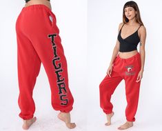 "Vintage 90s sweatpants by Russell in red with a Tiger Football logo, pockets, and a drawstring waist. Please see measurements and condition below. Every garment we sell is authentic vintage! You will receive the exact item photographed. Condition: Very good vintage. Best fits women's: Labelled Extra Large Tag: Russell Material:  Cotton Polyester blend MEASUREMENTS Taken from seam to seam while the garment is lying flat. Double the armpit, waist, and hips For reference, model is 5'9\" and measur Red Sporty Pants For Leisure, Red Sporty Leisure Pants, Red Sporty Sweatpants For Leisure, Red Sportswear Bottoms For Leisure, Red Cotton Sweatpants For Jogging, 90s Sweatpants, Red Sweatpants, Retro School, Tiger Football