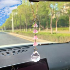 a car dashboard with a necklace hanging from it's dash board in front of the windshield