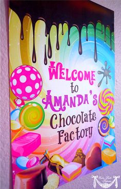 a welcome sign for amanda's chocolate factory with candy and lollipops