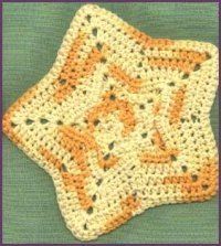 an orange and white crocheted dishcloth on a green surface with the words granny's corner written across it