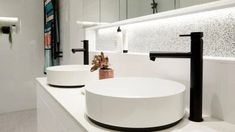 two white sinks sitting next to each other on top of a counter in a bathroom